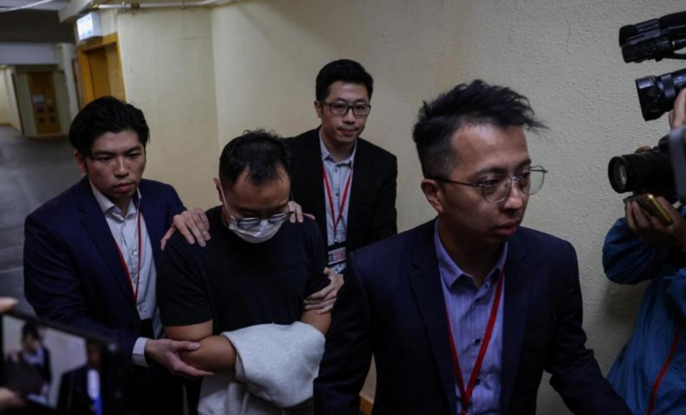 廉署人员押送一名嫌犯前往维修工程顾问公司鸿毅建筑师有限公司进行搜查